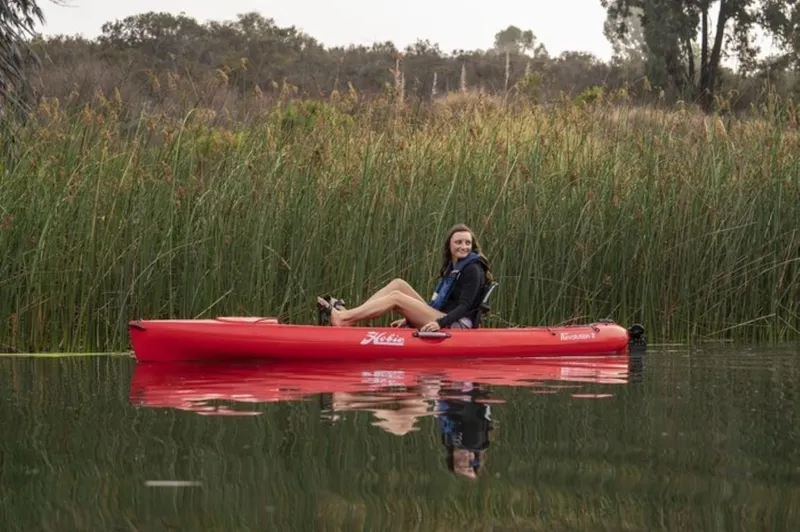 The Image of Woman kayaking on a 2023 Hobie Revolution 11 in a serene lake. - 0