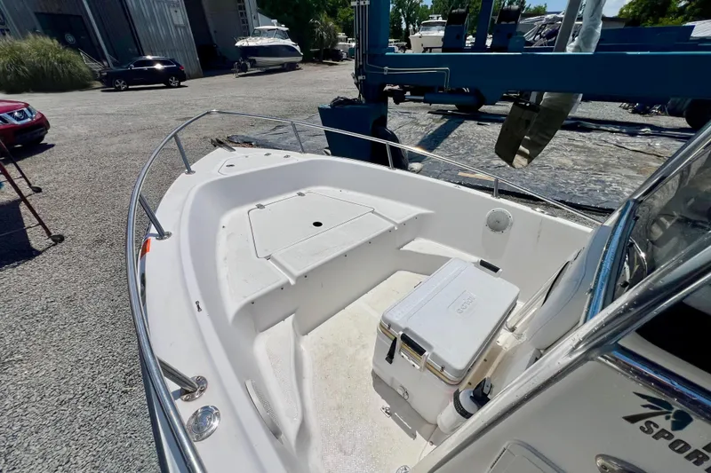 Slide: The Image of 2010 Key West 186 Sportsman boat, white deck, docked outdoors, featuring spacious seating area. - 16
