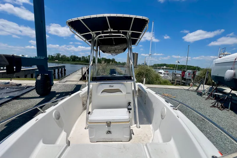 Slide: The Image of 2010 Key West 186 Sportsman boat docked, featuring a center console and T-top under a clear blue sky. - 18