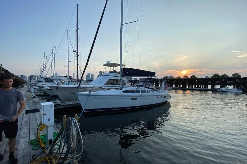 Slide: The Image of Sailboats docked at sunset, featuring a 1997 Hunter 340 model. - 2