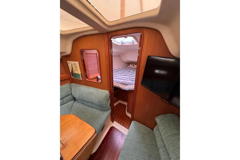 Slide: The Image of Interior of a 1997 Hunter 340 sailboat with cozy seating and a cabin view. - 4