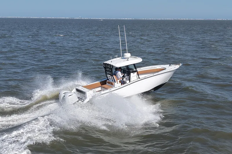 Slide: The Image of 2021 Cape Horn 32 T boat cruising on open water, creating splashes. - 14
