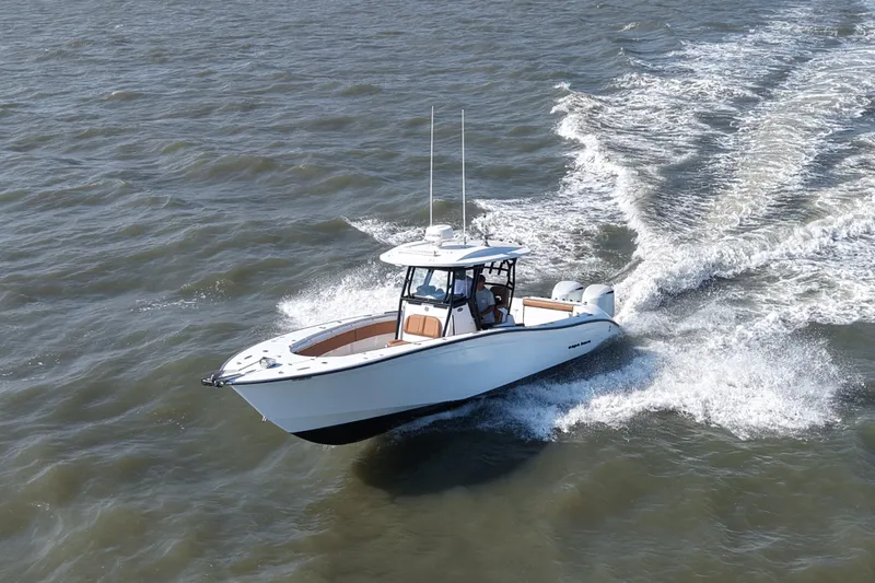 Slide: The Image of 2021 Cape Horn 32 T boat cruising on open water, creating a wake. - 17
