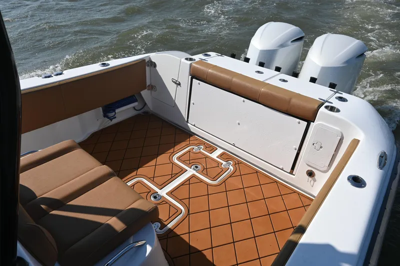 Slide: The Image of 2021 Cape Horn 32 T boat interior with brown seating and twin engines. - 35