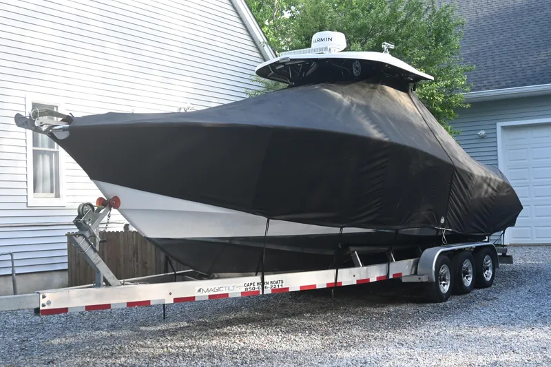 Slide: The Image of 2021 Cape Horn 32 T boat covered on trailer in residential driveway. - 44