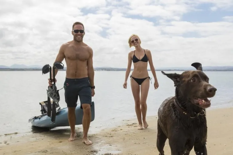 Slide: The Image of Couple with dog enjoying beach day with 2023 Hobie Revolution 13 kayak. - 3