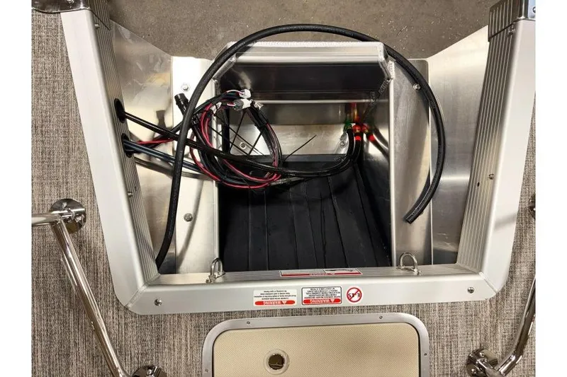 Slide: The Image of Open compartment of 2026 Bennington 24 M L-Bench with visible wiring and metal structure. - 25
