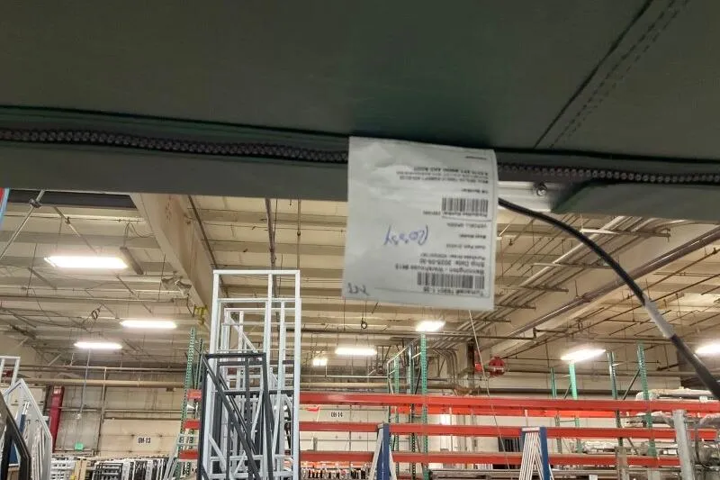 Slide: The Image of Factory interior with a Bennington 24 M L-Bench label, year 2026, hanging from a structure. - 8