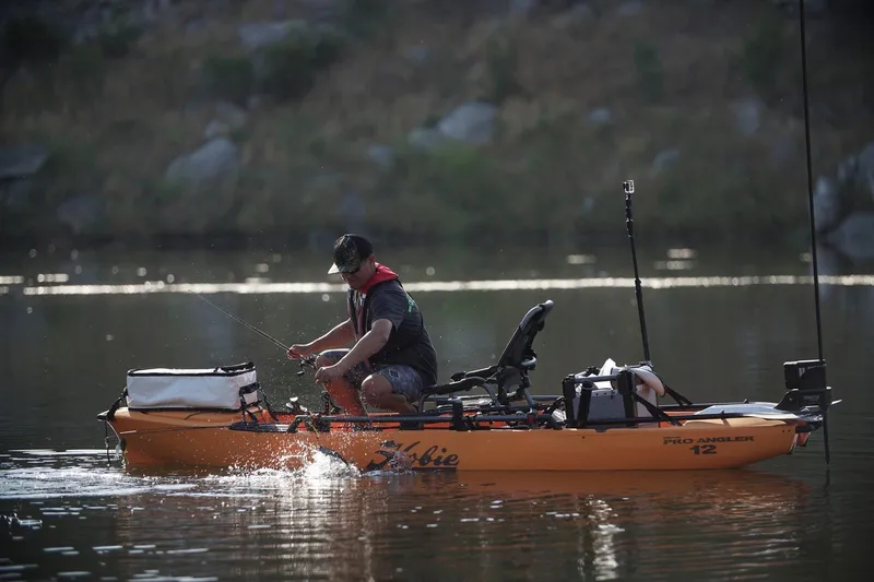 The Image of Man fishing on a 2023 Hobie Pro Angler 12 kayak in a calm lake. - 0