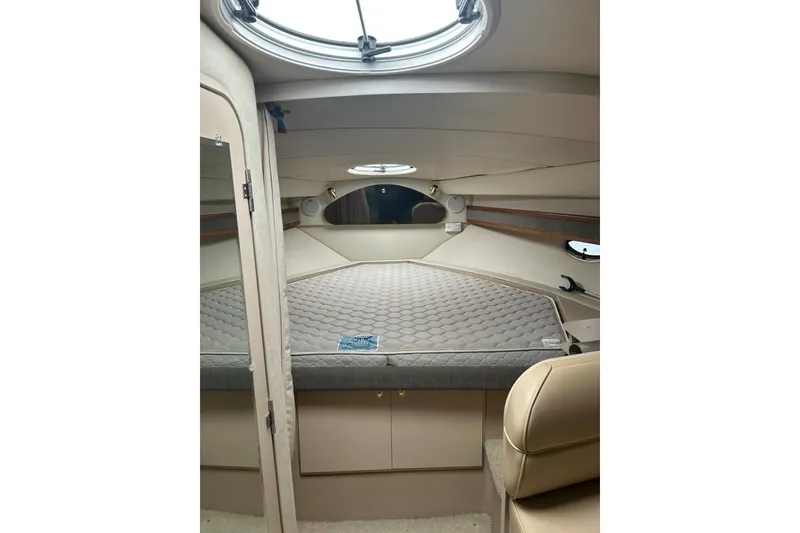 Slide: The Image of Interior cabin of 2000 Cruisers Yachts 3575 Express, featuring a cozy bed and porthole. - 10