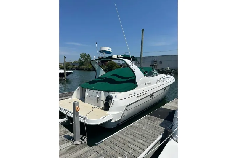 Slide: The Image of 2000 Cruisers Yachts 3575 Express docked, featuring green canopy and sleek design. - 15