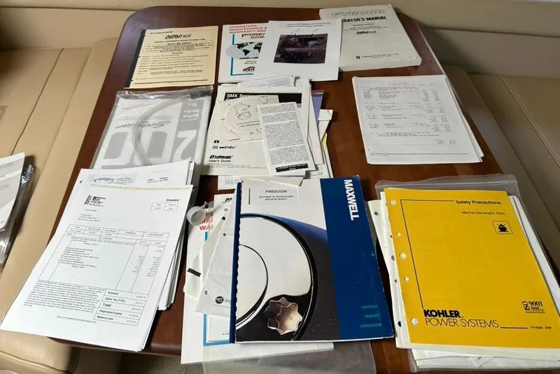 Slide: The Image of Assorted manuals and documents for 2000 Cruisers Yachts 3575 Express on a wooden table. - 19