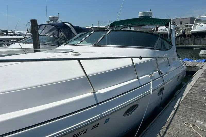 Slide: The Image of 2000 Cruisers Yachts 3575 Express docked at marina under clear blue sky. - 2