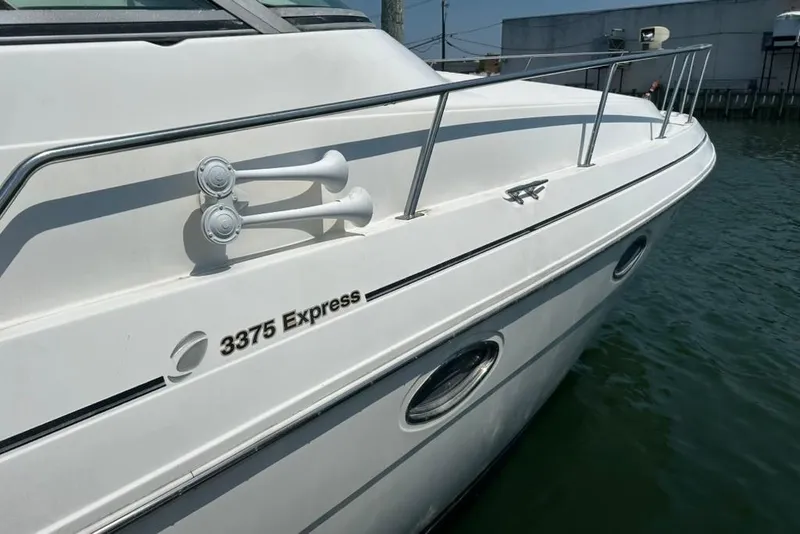 Slide: The Image of 2000 Cruisers Yachts 3575 Express boat docked, showcasing sleek white exterior and railings. - 4