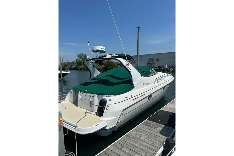 Slide: The Image of 2000 Cruisers Yachts 3575 Express docked, featuring green cover and sleek design. - 14