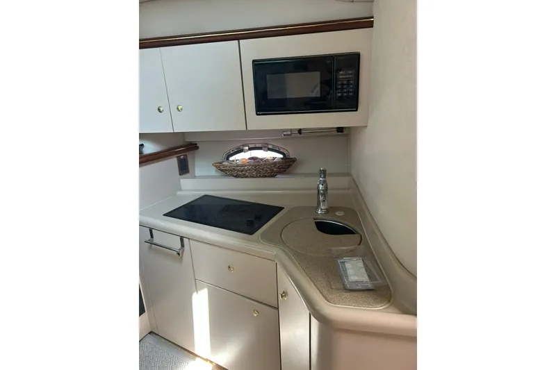 Slide: The Image of 2000 Cruisers Yachts 3575 Express galley with microwave, stovetop, and sink. - 9