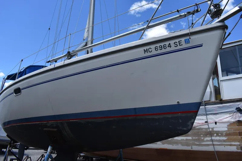 Slide: The Image of 2001 Catalina 310 sailboat on dry dock under a clear blue sky. - 1