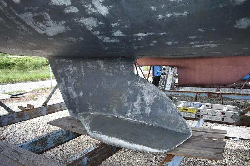 Slide: The Image of Keel of a 2001 Catalina 310 sailboat on a stand, showing wear and texture. - 13