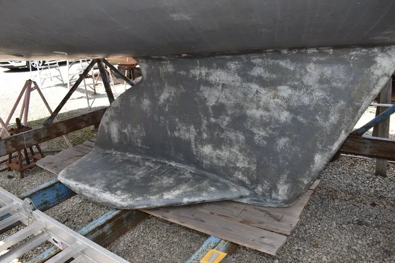 Slide: The Image of Keel of a 2001 Catalina 310 sailboat on a stand, showing wear and texture. - 15