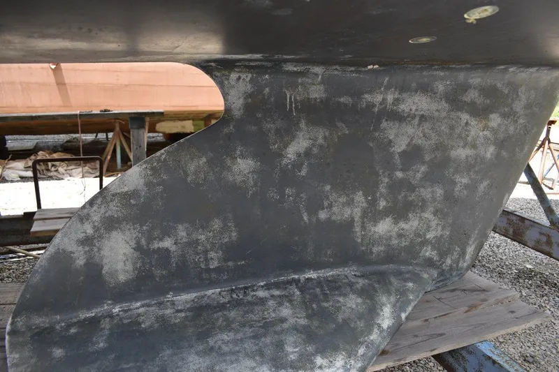 Slide: The Image of Close-up of a 2001 Catalina 310 sailboat keel in a boatyard setting. - 16