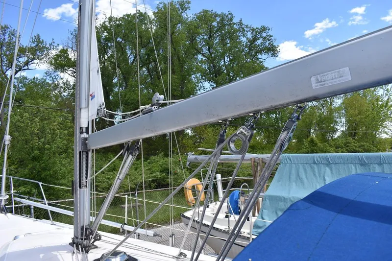 Slide: The Image of 2001 Catalina 310 sailboat mast and rigging against a backdrop of trees and blue sky. - 23