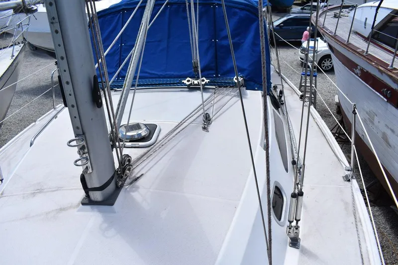 Slide: The Image of 2001 Catalina 310 sailboat deck with blue cover and rigging details. - 27