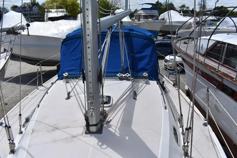 Slide: The Image of 2001 Catalina 310 sailboat with blue canopy, docked among other boats. - 28