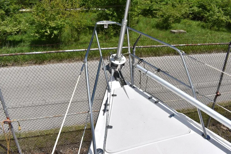 Slide: The Image of Bow of a 2001 Catalina 310 sailboat with metal railings and greenery in the background. - 29