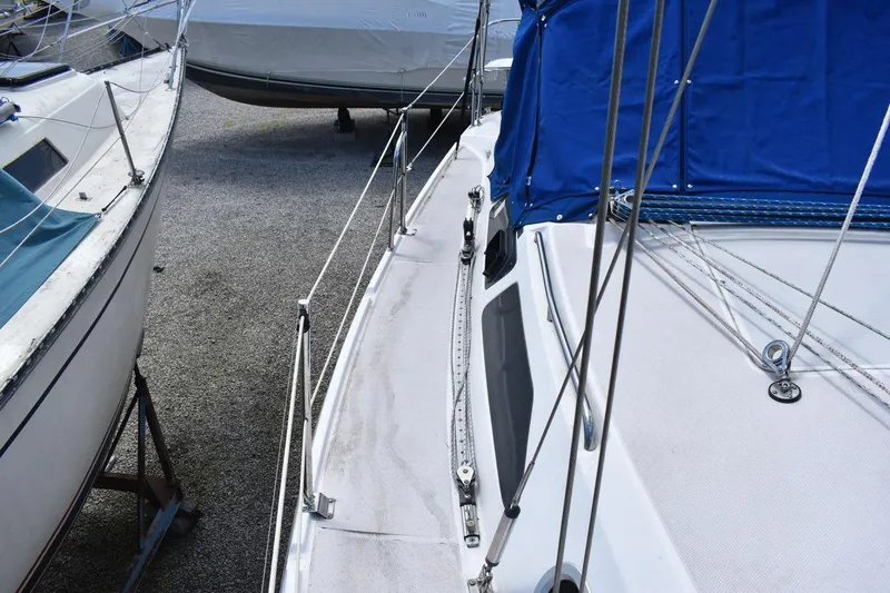 Slide: The Image of 2001 Catalina 310 sailboat deck with blue cover, docked alongside other boats. - 36