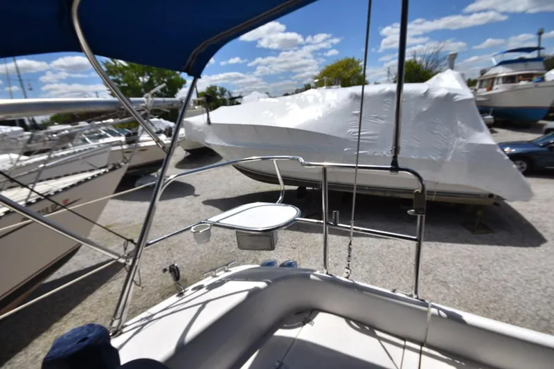 Slide: The Image of 2001 Catalina 310 sailboat in marina, surrounded by other boats under clear sky. - 39