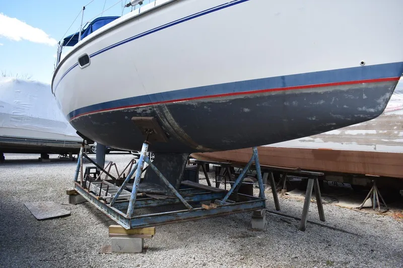 Slide: The Image of Catalina 310 sailboat from 2001 on a metal cradle, displayed outdoors. - 4