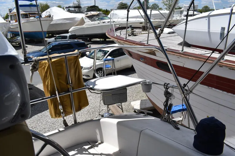 Slide: The Image of Boatyard scene with Catalina 310 sailboat, surrounded by other vessels and parked cars. - 40