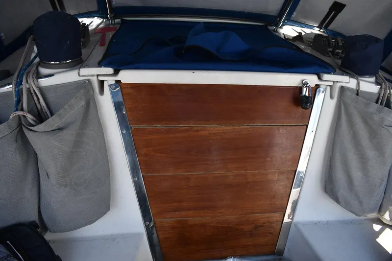 Slide: The Image of Interior view of a 2001 Catalina 310 sailboat cockpit with wooden hatch and storage bags. - 44