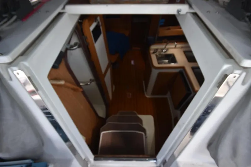 Slide: The Image of Interior view of a 2001 Catalina 310 sailboat, showing stairs and compact kitchen area. - 45