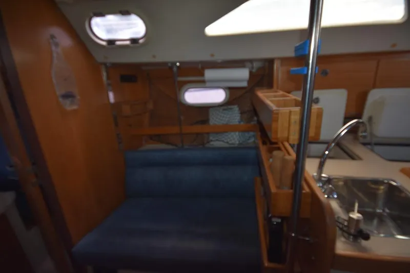 Slide: The Image of Interior of a 2001 Catalina 310 sailboat featuring a cozy seating area and compact kitchen. - 49
