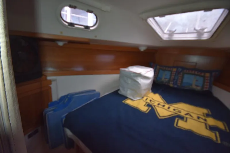 Slide: The Image of Cozy cabin interior of 2001 Catalina 310 sailboat with nautical-themed bedding. - 51