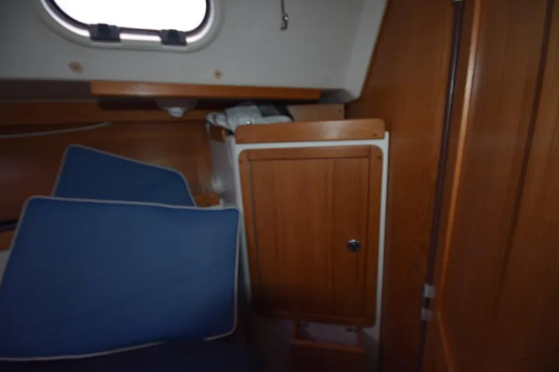 Slide: The Image of Interior cabin of a 2001 Catalina 310 sailboat with wooden cabinetry and blue cushions. - 53