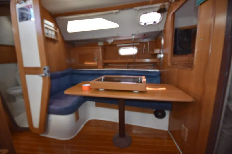 Slide: The Image of Interior of a 2001 Catalina 310 sailboat with wooden furnishings and a cozy dining area. - 54