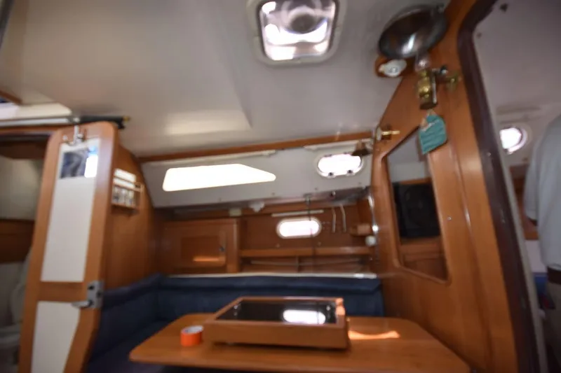 Slide: The Image of Interior of a 2001 Catalina 310 sailboat, featuring wooden cabinetry and seating area. - 55