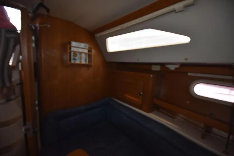 Slide: The Image of Interior of a 2001 Catalina 310 sailboat, featuring cozy seating and wooden paneling. - 56