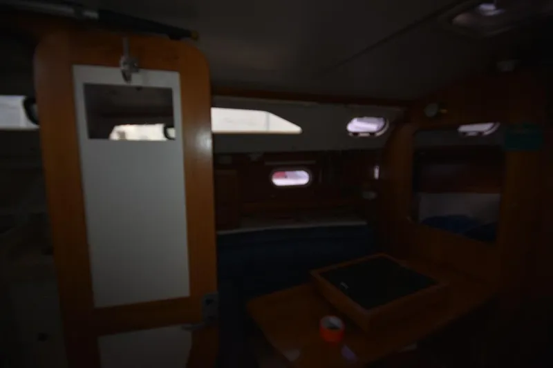 Slide: The Image of Dimly lit interior of a 2001 Catalina 310 sailboat cabin with wooden furnishings. - 58