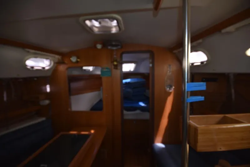 Slide: The Image of Interior of a 2001 Catalina 310 sailboat, featuring cozy wooden furnishings and seating. - 65