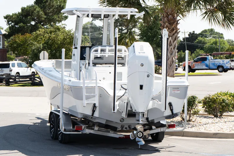 Slide: The Image of 2026 Blazer Bay Makaira 2600 boat on trailer, parked outdoors near palm trees. - 4