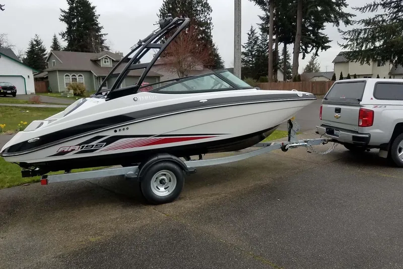 The Image of 2017 Yamaha AR195 boat on trailer, hitched to a silver truck in suburban neighborhood. - 5