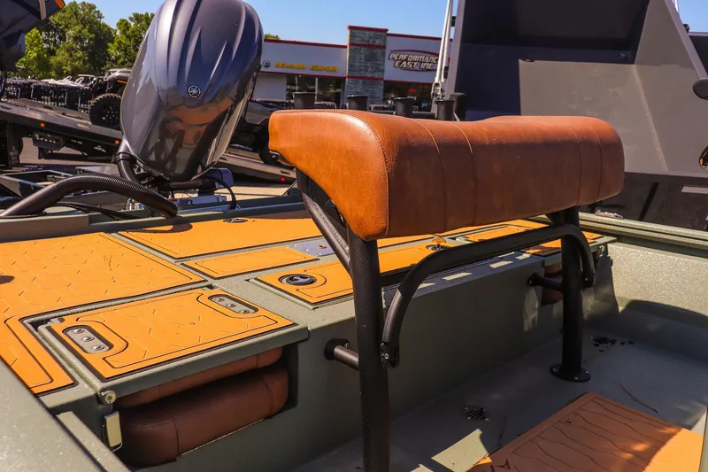 Slide: The Image of 2026 Avid 21 FSX boat interior with leather seating and motor, parked outdoors. - 10