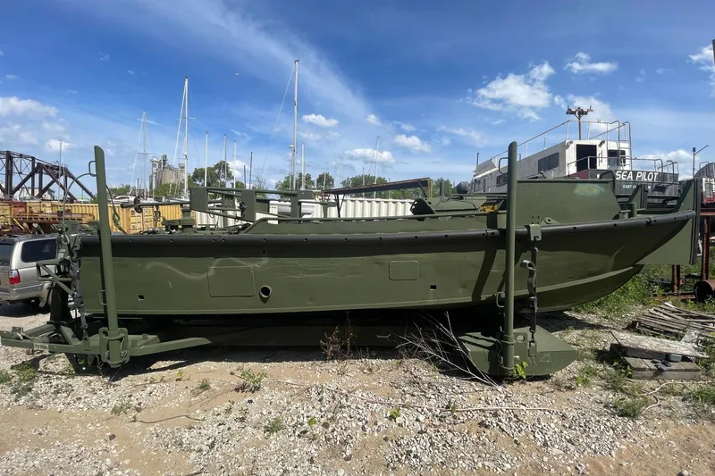 Slide: The Image of US Army M2R Bridge Erection Boat, 1997 model, parked on gravel with blue sky background. - 2