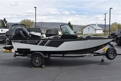 The Image of 2026 Lowe Fishing Machine 1675 WT boat on trailer, parked outdoors. - 0