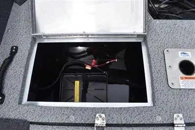 Slide: The Image of 2026 Lowe Fishing Machine 1675 WT battery compartment with open hatch and visible wiring. - 11