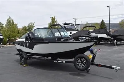 Slide: The Image of 2026 Lowe Fishing Machine 1675 WT on trailer, parked outdoors, showcasing sleek design and modern features. - 2