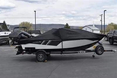 Slide: The Image of 2026 Lowe Fishing Machine 1675 WT boat with cover on trailer in parking lot. - 34